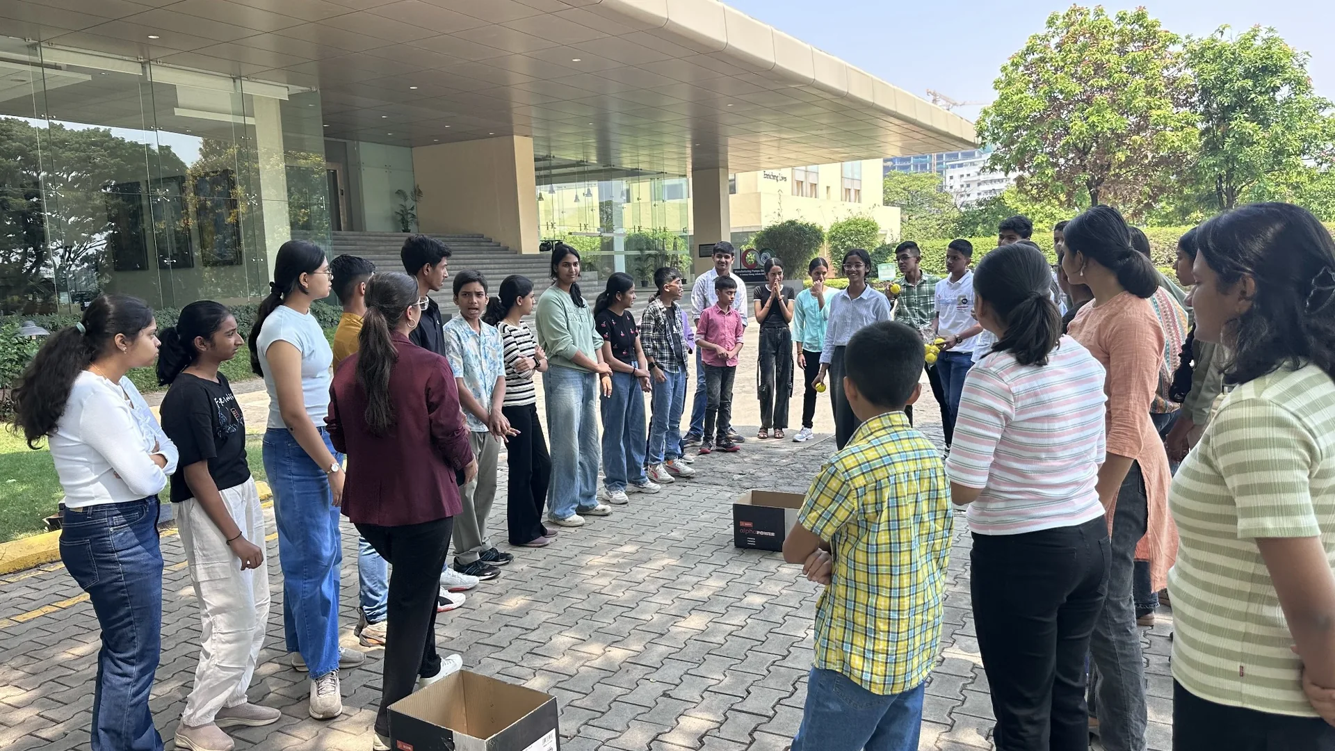 Participants standing in a circle for an outdoor group activity.